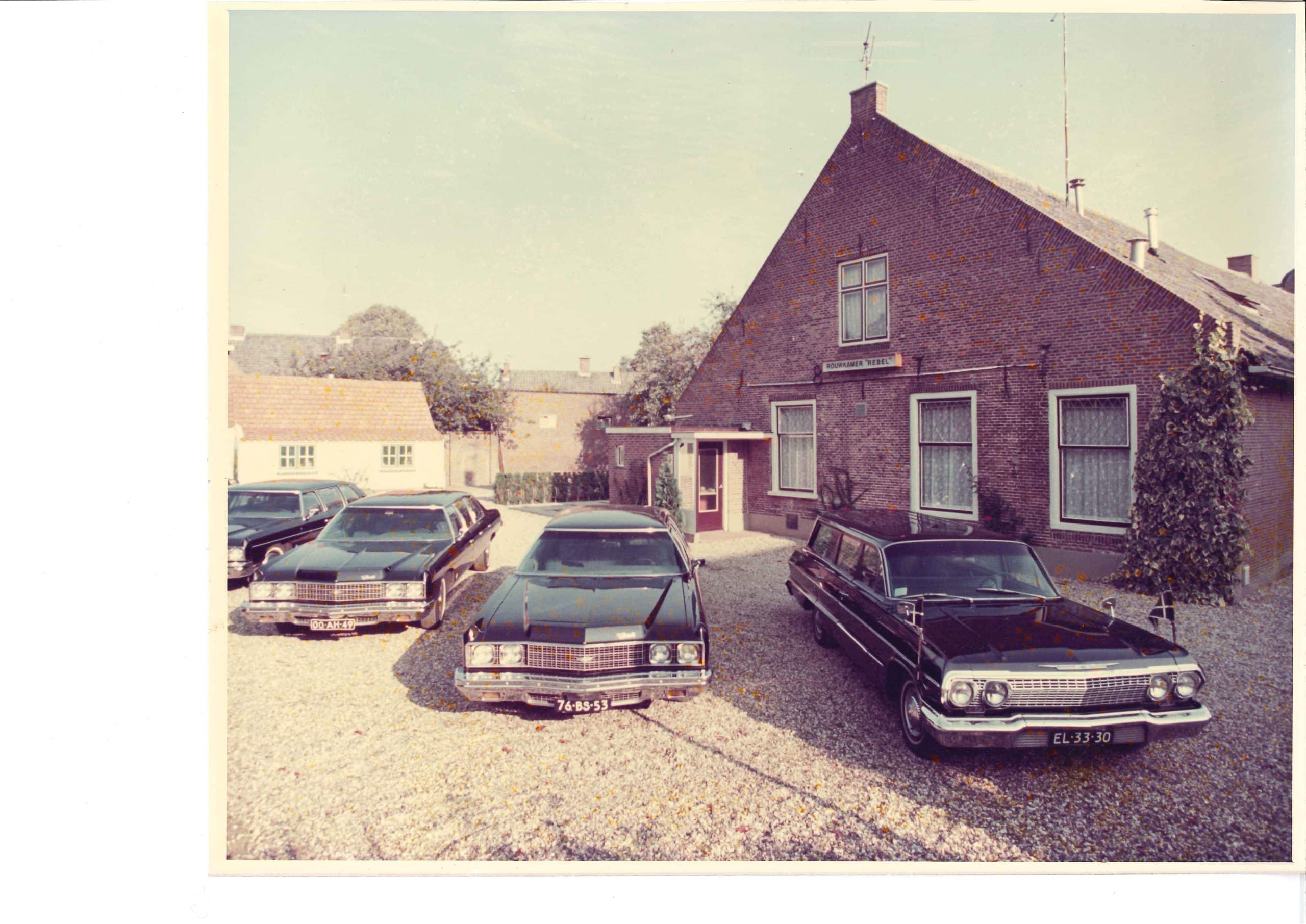 Historische foto van het pand van Rebel met de rouwauto's ervoor