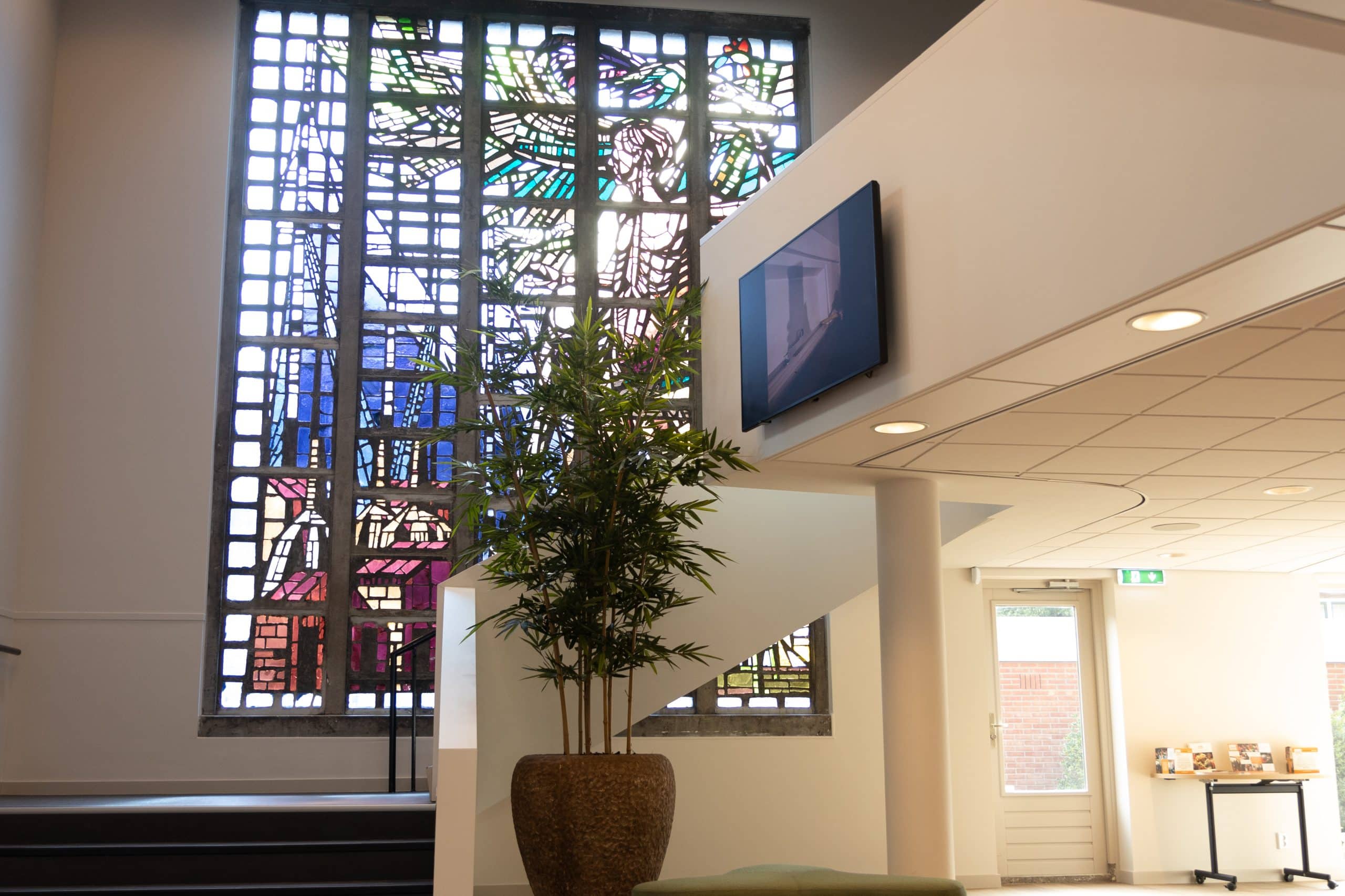 Hal van uitvaartcentrum het Visnet in Huizen met glas-in-loodraam